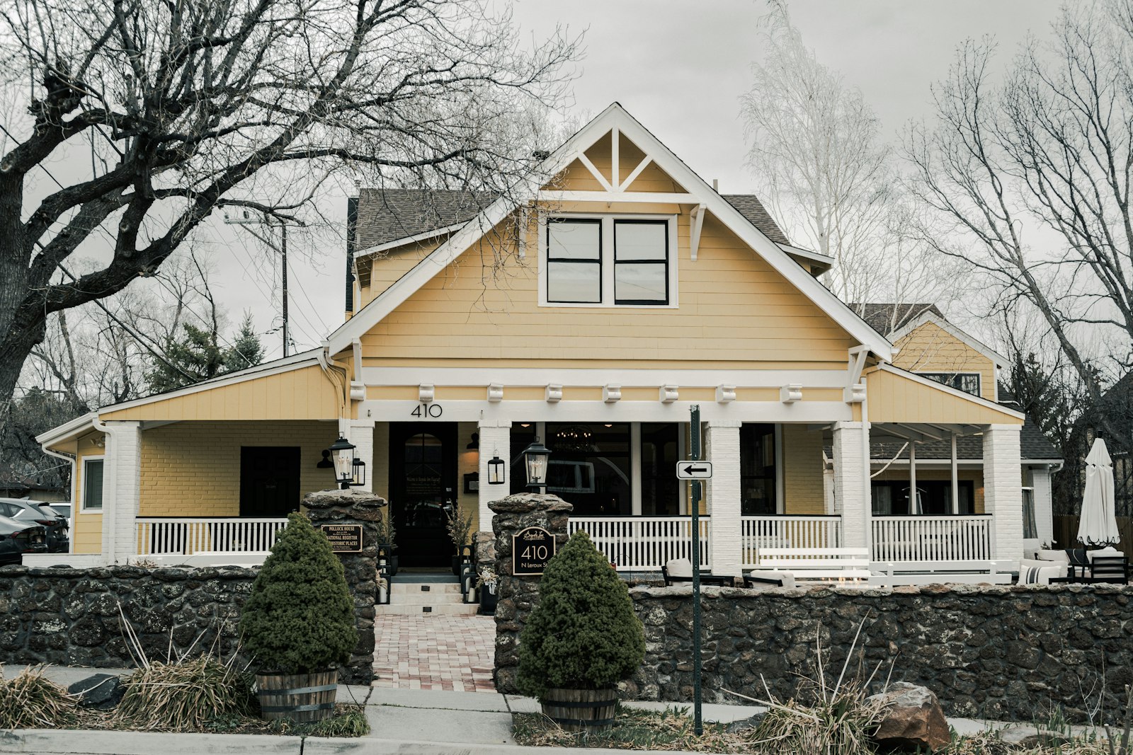 A charming yellow house with a large porch.
